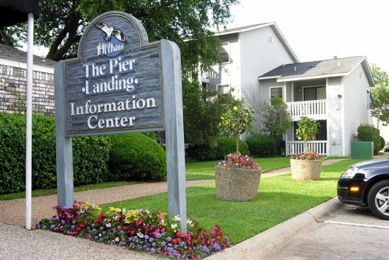 Pier Landing tall wood information center sign with parking lot
